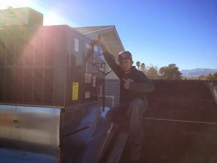 HVAC technician performing Air Duct Cleaning on a rooftop unit in Paloma Creek South