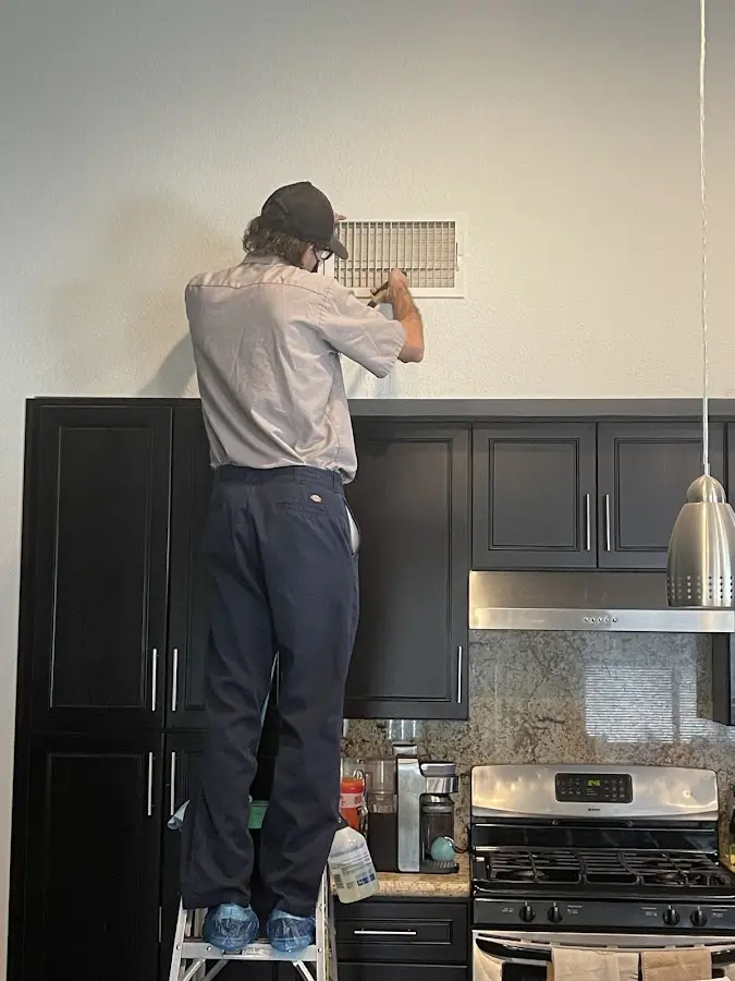 Technician inspecting an air vent during HVAC service in Paloma Creek South